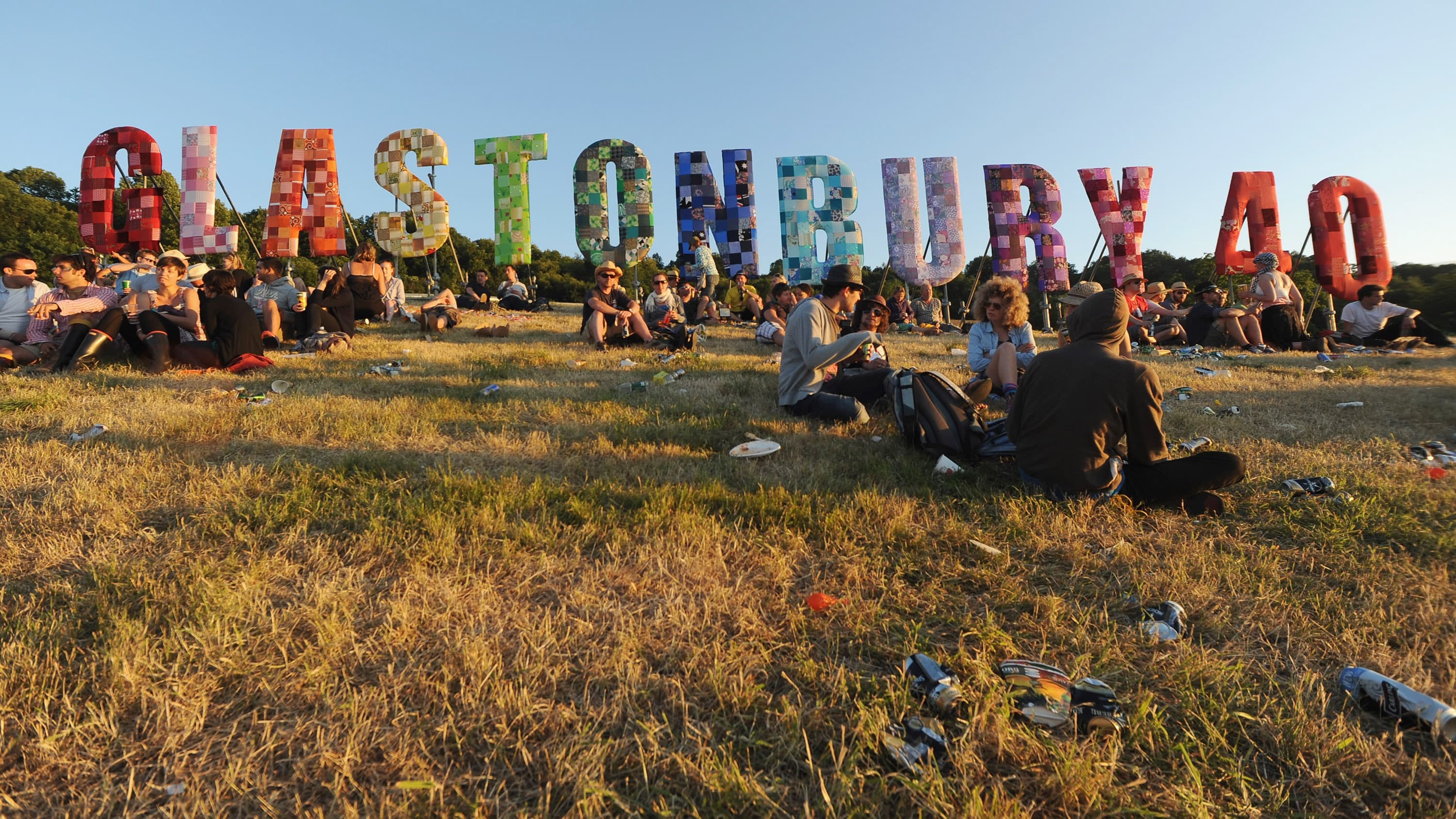 GLASTONBURY, ENGLAND - JUNE 24: Festival goers relax in a field at sunset during Day 1 of the Glastonbury Festival on June 24, 2010 in Glastonbury, England. This year sees the 40th anniversary of the festival which was started by a dairy farmer, Michael Evis in 1970 and has grown into the largest music festival in Europe. (Photo by Ian Gavan/Getty Images)